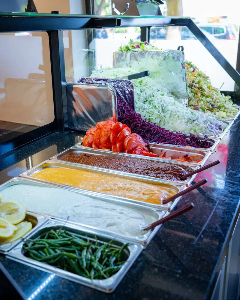 Frisch vorbereitete Salate und Zutaten in der Frischetheke von Amca's Kebab