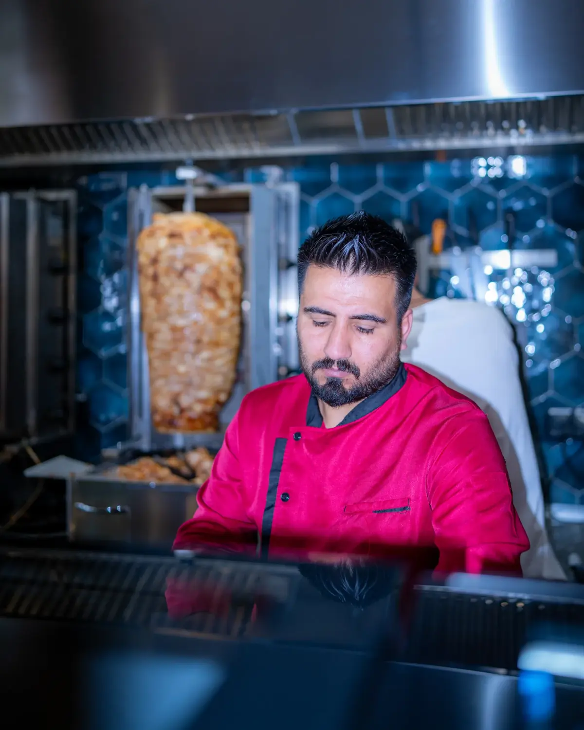 Koch von Amca's Kebab schneidet konzentriert Fleisch vom Dönerspieß