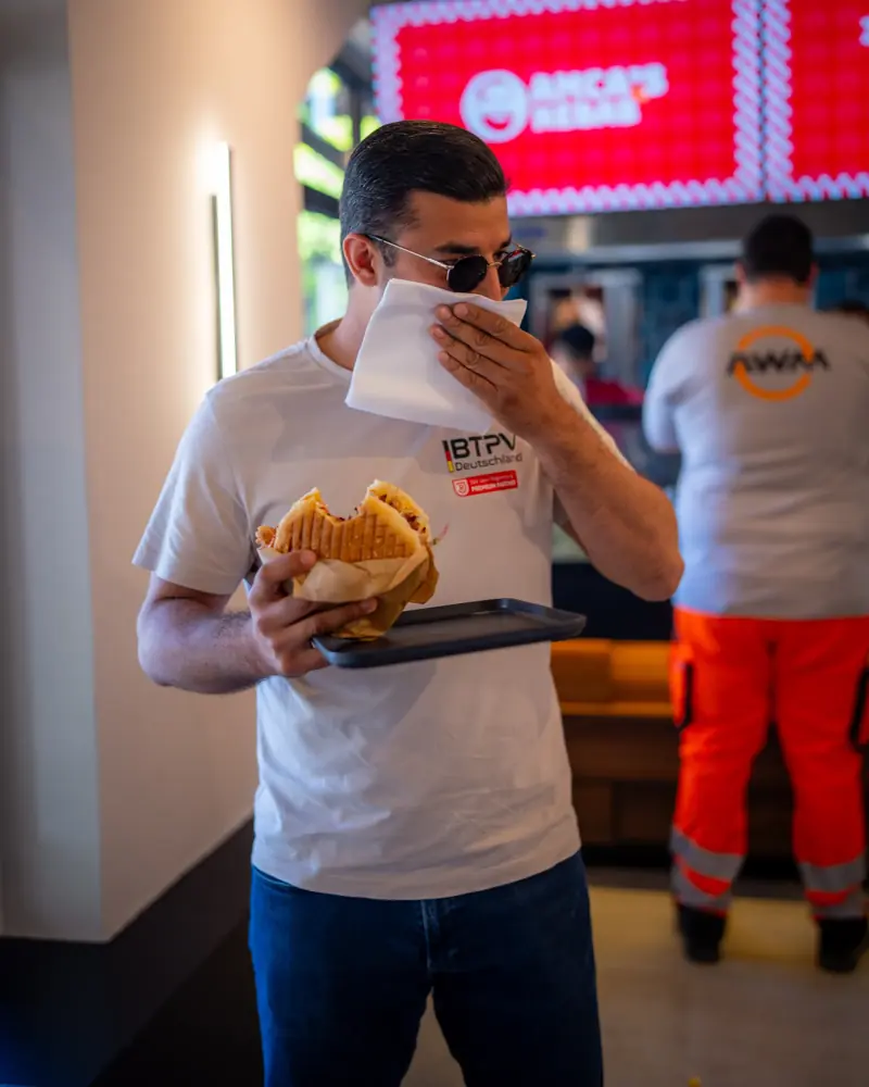 Gast beißt genüsslich in einen frischen Döner