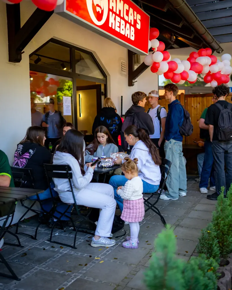 Volle Terrasse mit rot-weißen Ballons bei der Eröffnung von Amca's Kebab