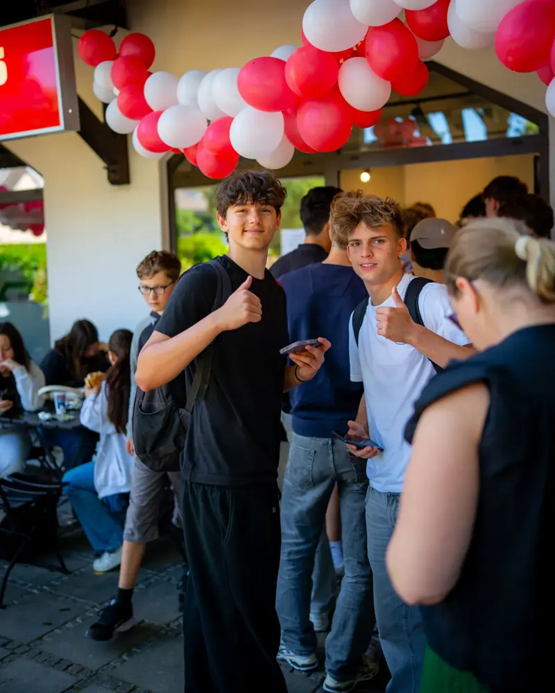 Gäste feiern unter rot-weißen Ballons im Lokal von Amca's Kebab